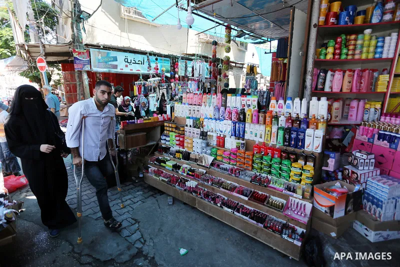 Palestinian disabled Mohammed Al Akhras, 32, who lost his leg by Israeli troops during clashes at Gaza-Israel border uses his crutch to walk at market as he shopping ahead of Eid al-Fitr holiday, in Rafah in the southern...