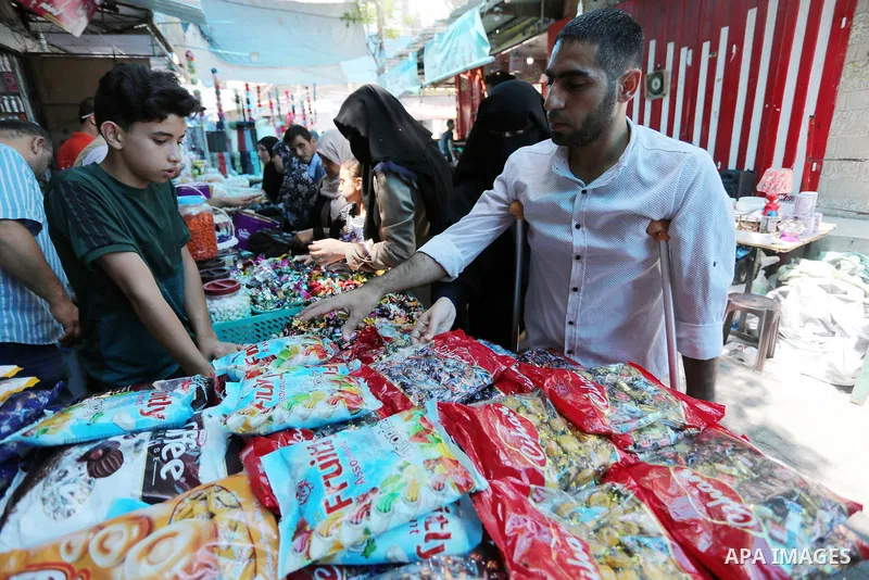 Palestinian disabled Mohammed Al Akhras, 32, who lost his leg by Israeli troops during clashes at Gaza-Israel border uses his crutch to walk at market as he shopping ahead of Eid al-Fitr holiday, in Rafah in the southern...