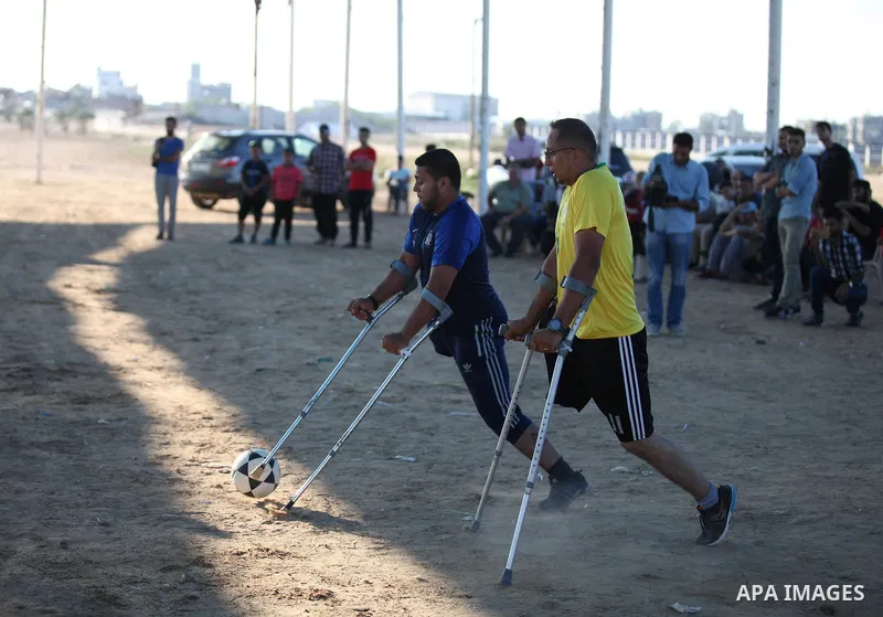 Disabled Palestinians who lost their legs by Israeli troops during clashes at Gaza-Israel border play a football match at Gaza-Israel border in conjunction with the opening of the 2018 FIFA World Cup held in Russia, in e...