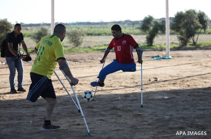 Disabled Palestinians who lost their legs by Israeli troops during clashes at Gaza-Israel border play a football match at Gaza-Israel border in conjunction with the opening of the 2018 FIFA World Cup held in Russia, in e...