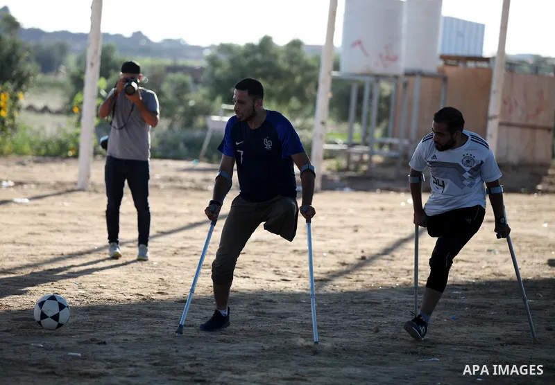 Disabled Palestinians who lost their legs by Israeli troops during clashes at Gaza-Israel border play a football match at Gaza-Israel border in conjunction with the opening of the 2018 FIFA World Cup held in Russia, in e...