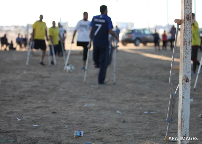Disabled Palestinians who lost their legs by Israeli troops during clashes at Gaza-Israel border play a football match at Gaza-Israel border in conjunction with the opening of the 2018 FIFA World Cup held in Russia, in e...