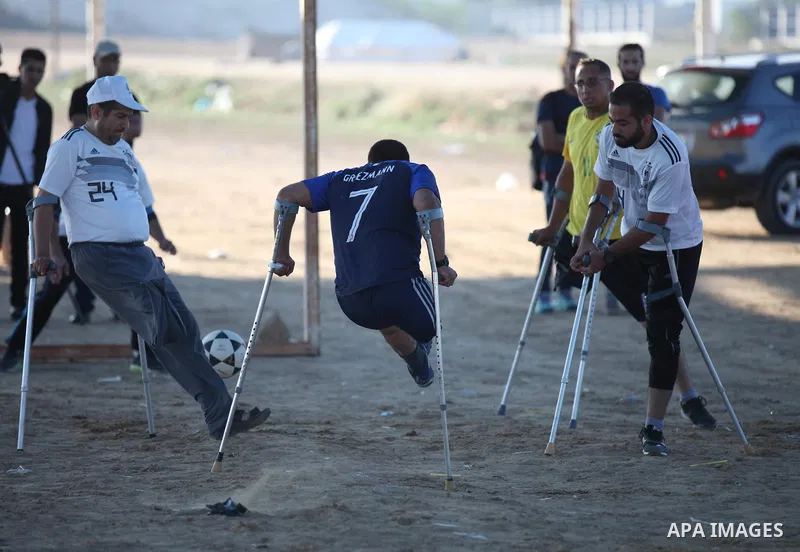 Disabled Palestinians who lost their legs by Israeli troops during clashes at Gaza-Israel border play a football match at Gaza-Israel border in conjunction with the opening of the 2018 FIFA World Cup held in Russia, in e...