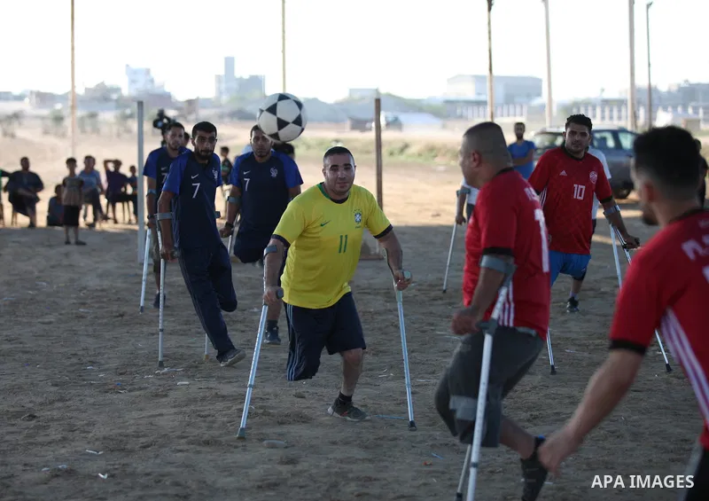 Disabled Palestinians who lost their legs by Israeli troops during clashes at Gaza-Israel border play a football match at Gaza-Israel border in conjunction with the opening of the 2018 FIFA World Cup held in Russia, in e...