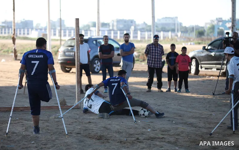 Disabled Palestinians who lost their legs by Israeli troops during clashes at Gaza-Israel border play a football match at Gaza-Israel border in conjunction with the opening of the 2018 FIFA World Cup held in Russia, in e...