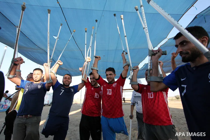Disabled Palestinians who lost their legs by Israeli troops during clashes at Gaza-Israel border play a football match at Gaza-Israel border in conjunction with the opening of the 2018 FIFA World Cup held in Russia, in e...
