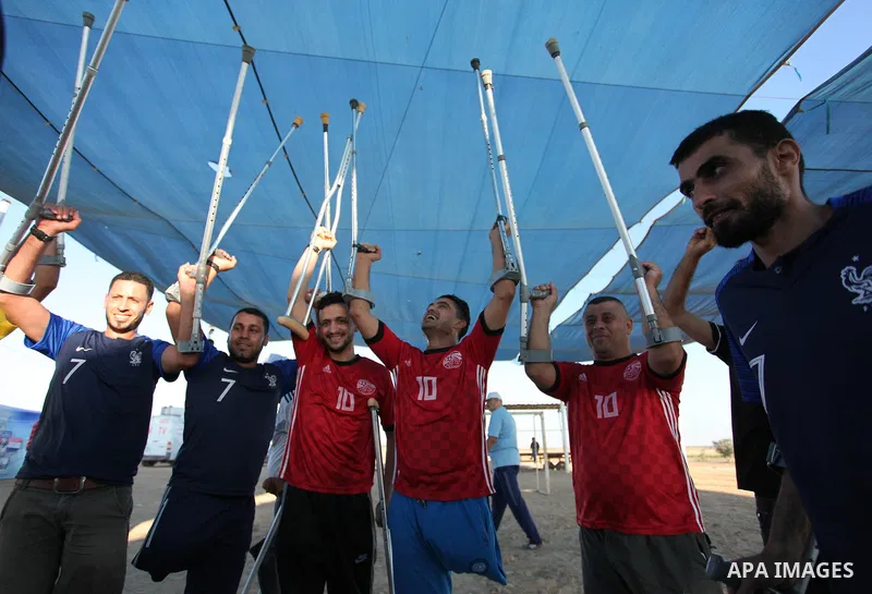 Disabled Palestinians who lost their legs by Israeli troops during clashes at Gaza-Israel border play a football match at Gaza-Israel border in conjunction with the opening of the 2018 FIFA World Cup held in Russia, in e...