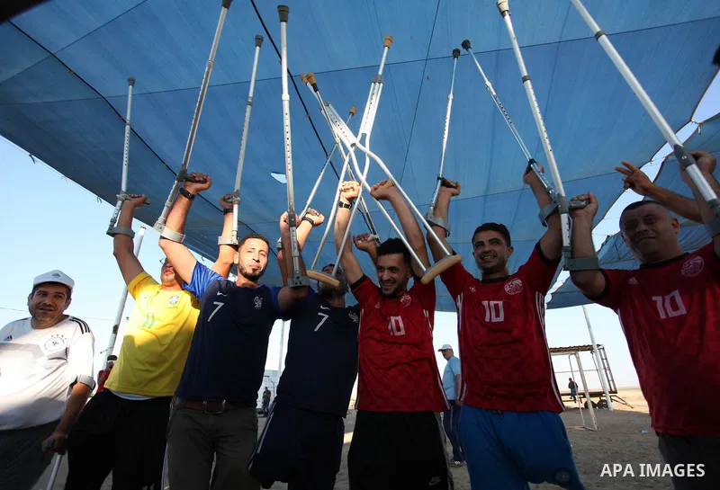 Disabled Palestinians who lost their legs by Israeli troops during clashes at Gaza-Israel border play a football match at Gaza-Israel border in conjunction with the opening of the 2018 FIFA World Cup held in Russia, in e...