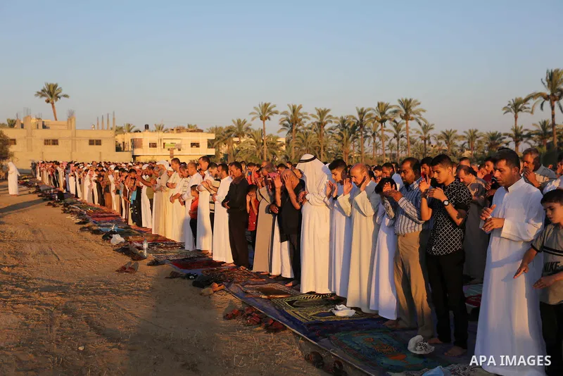 Palestinian Muslim worshipers perform Eid al-Fitr prayer, at the Israel-Gaza border in Khan Younis in the southern Gaza Strip on June 15, 2018. Eid al-Fitr marks the end of Muslim's holy fasting month of Ramadan when fai...
