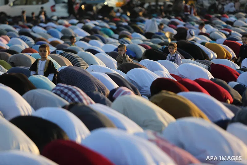 Palestinian Muslim worshipers perform Eid al-Fitr prayer, at the Israel-Gaza border in Khan Younis in the southern Gaza Strip on June 15, 2018. Eid al-Fitr marks the end of Muslim's holy fasting month of Ramadan when fai...