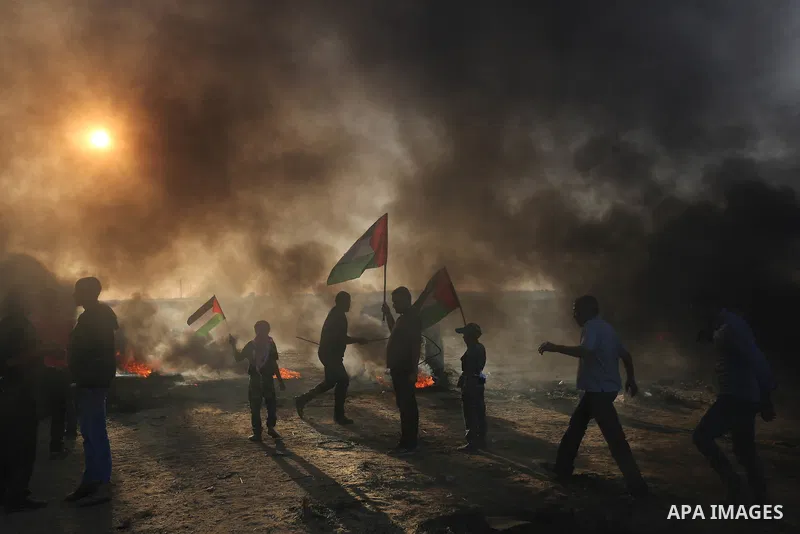 Palestinian protesters burn tires on the first day of Eid al-Fitr, at the Israel-Gaza border in Khan Younis in the southern Gaza Strip on June 15, 2018. Photo by Ashraf Amra