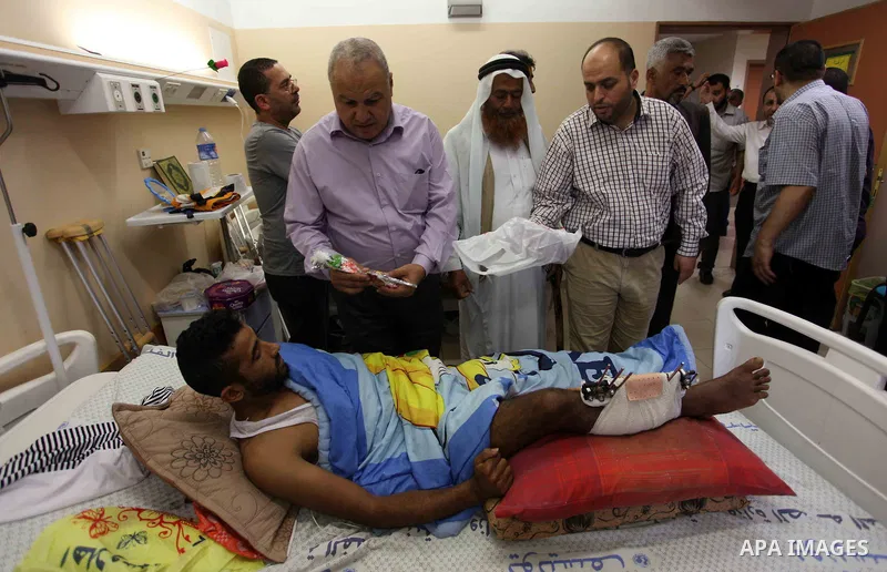 Palestinian members of the National Commission to break the siege, visit the youths who were wounded during clashes with Israeli troops at the Israel-Gaza border on the second day of Eid al-Fitr holiday at al-shifa hospi...