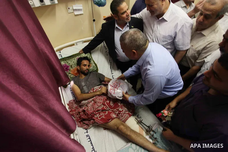 Palestinian members of the National Commission to break the siege, visit the youths who were wounded during clashes with Israeli troops at the Israel-Gaza border on the second day of Eid al-Fitr holiday at al-shifa hospi...