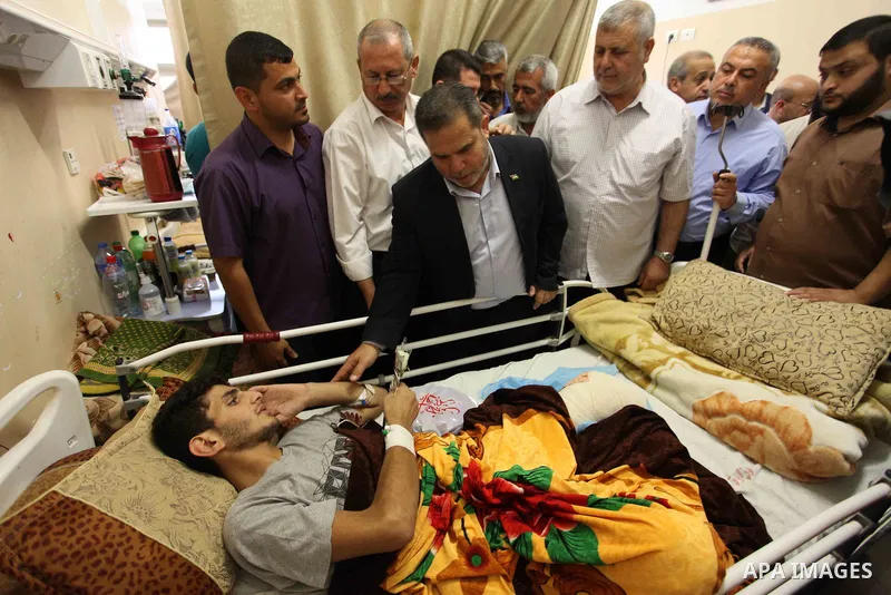 Palestinian members of the National Commission to break the siege, visit the youths who were wounded during clashes with Israeli troops at the Israel-Gaza border on the second day of Eid al-Fitr holiday at al-shifa hospi...