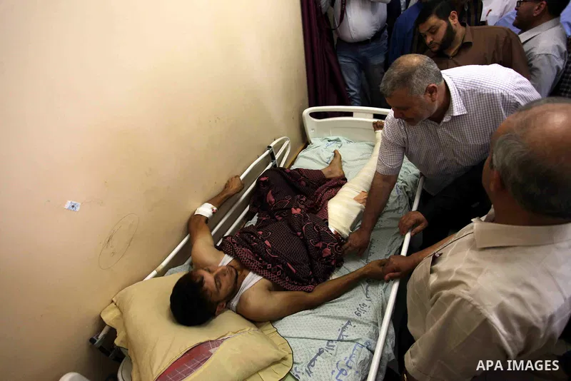 Palestinian members of the National Commission to break the siege, visit the youths who were wounded during clashes with Israeli troops at the Israel-Gaza border on the second day of Eid al-Fitr holiday at al-shifa hospi...