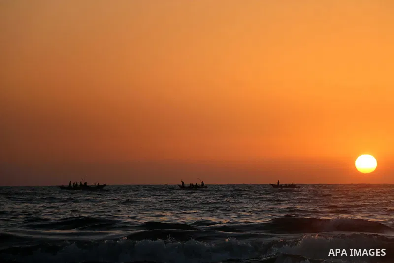 A Palestinian youth swims on the Mediterranean Sea in Gaza City on the third day of Eid al-Fitr holiday which marks the end of the Muslim holy month of Ramadan, during sunset on June 17, 2018. Photo by Mahmoud Khattab