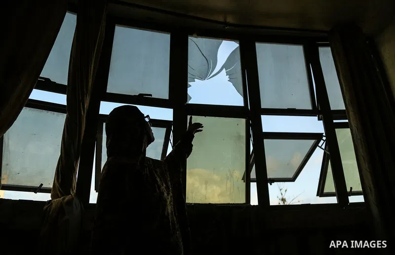 A Palestinian woman inspects a damge window after an airstrike by Israeli forces in the northern of Gaza Strip Gaza City on June 18, 2018. Photo by Dawoud Abo Alkas