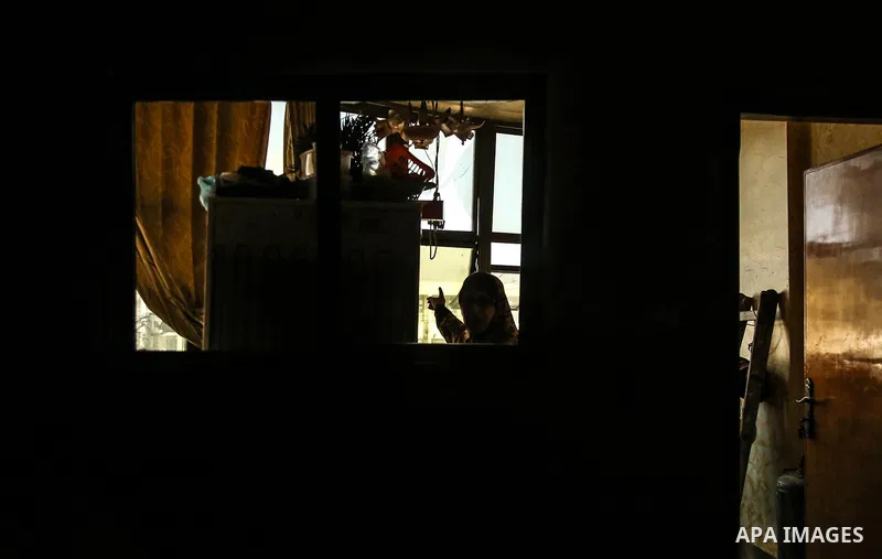 A Palestinian woman inspects a damge window after an airstrike by Israeli forces in the northern of Gaza Strip Gaza City on June 18, 2018. Photo by Dawoud Abo Alkas