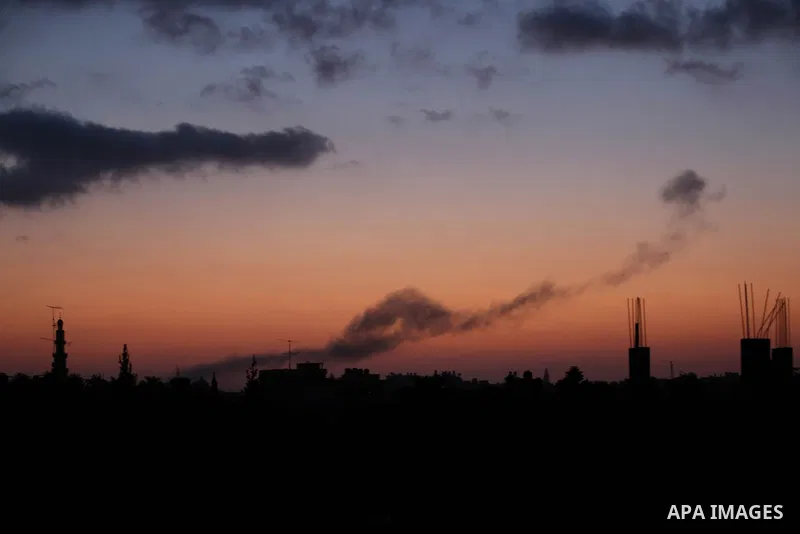 A picture taken from Rafah town in the southern Gaza Strip on June 20, 2018, shows a smoke billowing in the background following an Israeli air strike on the Palestinian enclave. Photo by Ashraf Amra