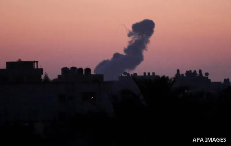 A picture taken from Rafah town in the southern Gaza Strip on June 20, 2018, shows a smoke billowing in the background following an Israeli air strike on the Palestinian enclave. Photo by Ashraf Amra