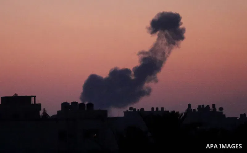A picture taken from Rafah town in the southern Gaza Strip on June 20, 2018, shows a smoke billowing in the background following an Israeli air strike on the Palestinian enclave. Photo by Ashraf Amra