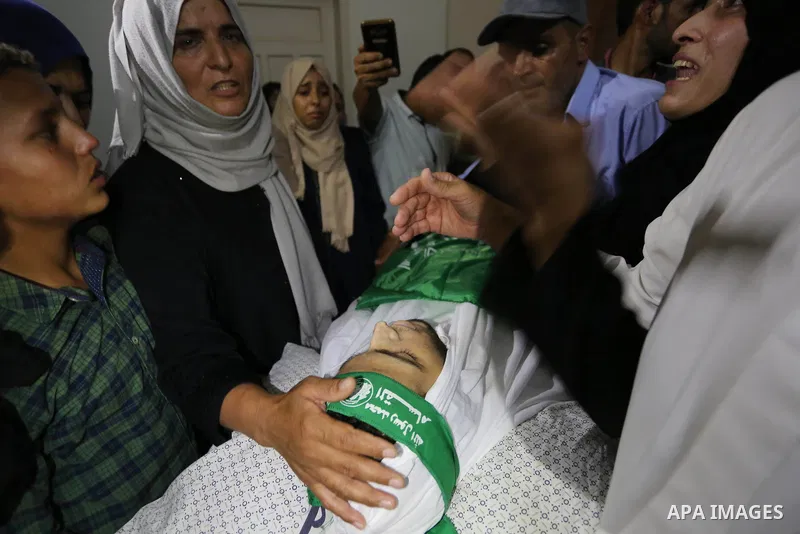 Relatives of Palestinian Mohammed Abu Daqqa, 24, who died of wounds he sustained during clashes with Israeli troops, mourn over his body during his funeral in Khan Younis in the southern Gaza Strip on June 21, 2018. Phot...