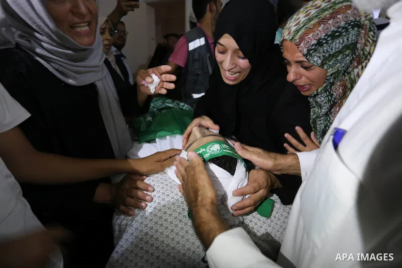 Relatives of Palestinian Mohammed Abu Daqqa, 24, who died of wounds he sustained during clashes with Israeli troops, mourn over his body during his funeral in Khan Younis in the southern Gaza Strip on June 21, 2018. Phot...