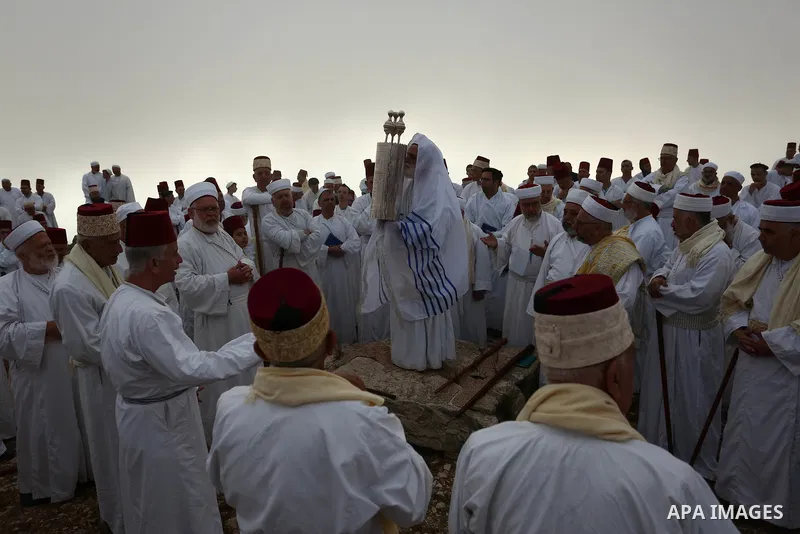 Samaritan worshipers pray on the top of Mount Gerizim in a traditional pilgrimage to mark the Shavuot's holiday at dawn near the West Bank city of Nablus June 24, 2018 which is giving of the Torah at Mount Sinai seven we...