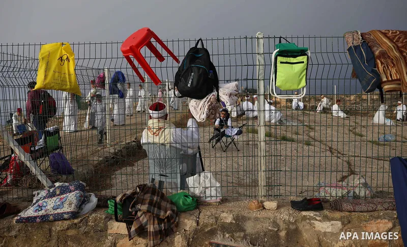 Samaritan worshipers pray on the top of Mount Gerizim in a traditional pilgrimage to mark the Shavuot's holiday at dawn near the West Bank city of Nablus June 24, 2018 which is giving of the Torah at Mount Sinai seven we...