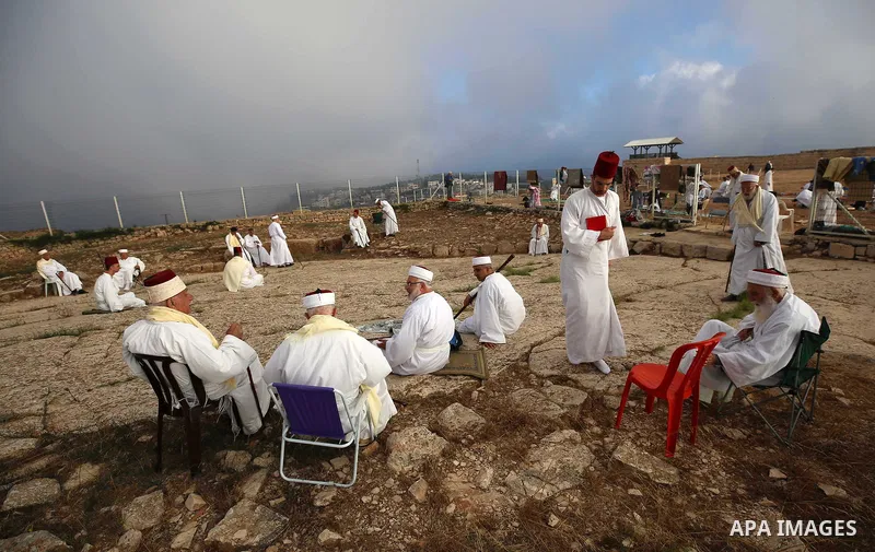 Samaritan worshipers pray on the top of Mount Gerizim in a traditional pilgrimage to mark the Shavuot's holiday at dawn near the West Bank city of Nablus June 24, 2018 which is giving of the Torah at Mount Sinai seven we...
