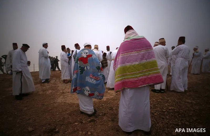 Samaritan worshipers pray on the top of Mount Gerizim in a traditional pilgrimage to mark the Shavuot's holiday at dawn near the West Bank city of Nablus June 24, 2018 which is giving of the Torah at Mount Sinai seven we...