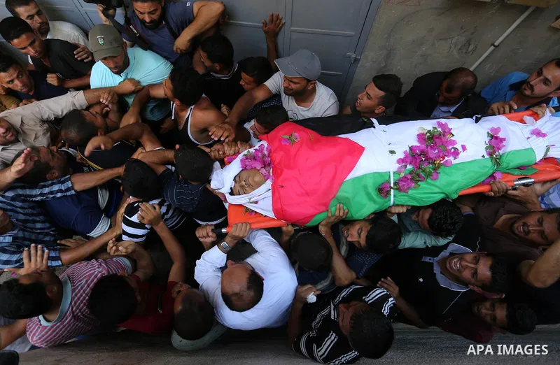 Mourners carry the body of Palestinian Osama Abu Khater, who died of wounds he sustained during clashes with Israeli troops, his funeral in Khan Younis in the southern Gaza Strip on June 24, 2018. Photo by Ashraf Amra