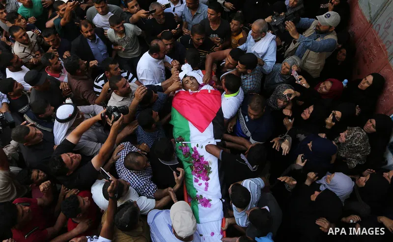 Mourners carry the body of Palestinian Osama Abu Khater, who died of wounds he sustained during clashes with Israeli troops, his funeral in Khan Younis in the southern Gaza Strip on June 24, 2018. Photo by Ashraf Amra
