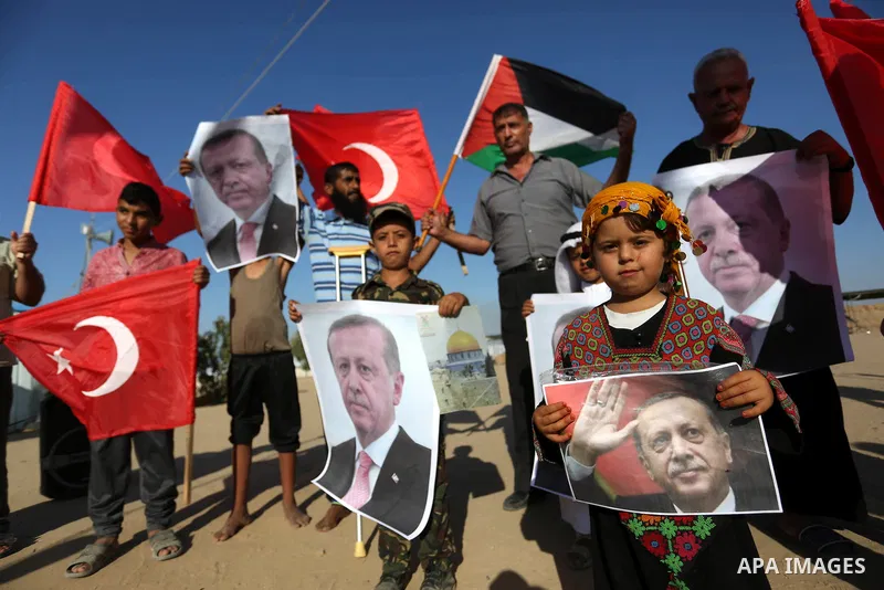 Palestinians hold portraits of Turkish President Recep Tayyip Erdogan during a rally to support with Turkey's presidential and parliamentary elections in Al-Bureij in the center of Gaza Strip on June 24, 2018. Photo by A...