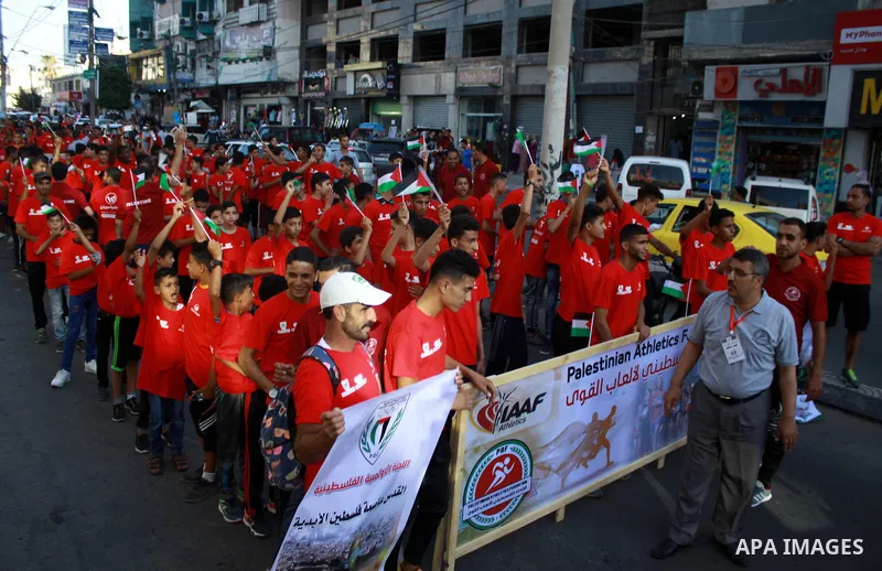Palestinian scouts take part in a march marking the Palestinian Olympic Day, in Gaza city, on June 24, 2018. Photo by Bashar Zakri
