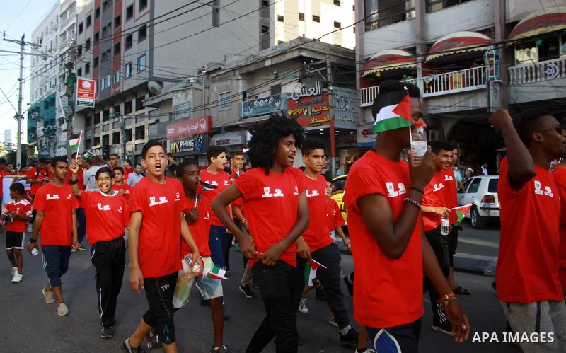 Palestinian scouts take part in a march marking the Palestinian Olympic Day, in Gaza city, on June 24, 2018. Photo by Bashar Zakri