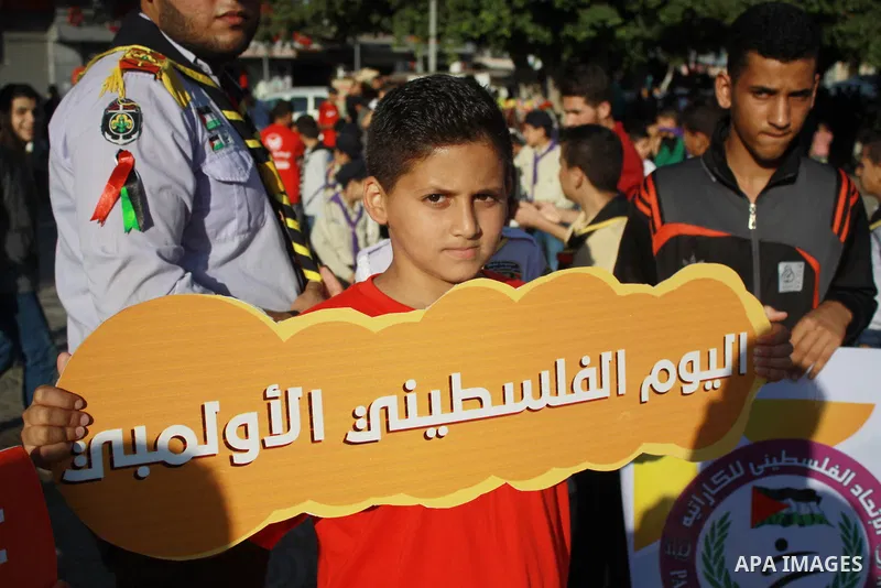 Palestinian scouts take part in a march marking the Palestinian Olympic Day, in Gaza city, on June 24, 2018. Photo by Bashar Zakri