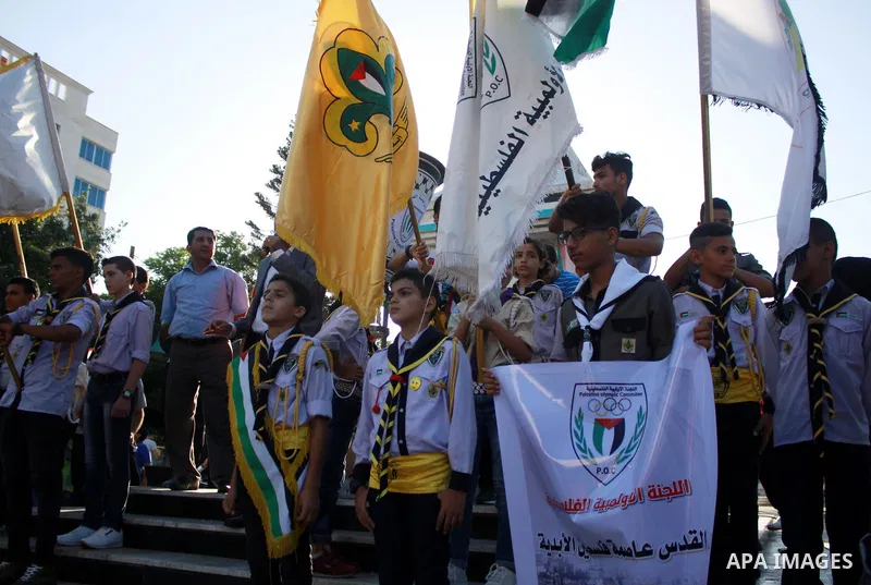 Palestinian scouts take part in a march marking the Palestinian Olympic Day, in Gaza city, on June 24, 2018. Photo by Bashar Zakri
