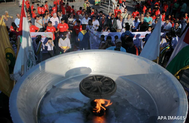 Palestinians light an urn marking the Palestinian Olympic Day, in Gaza city, on June 24, 2018. Photo by Bashar Zakri