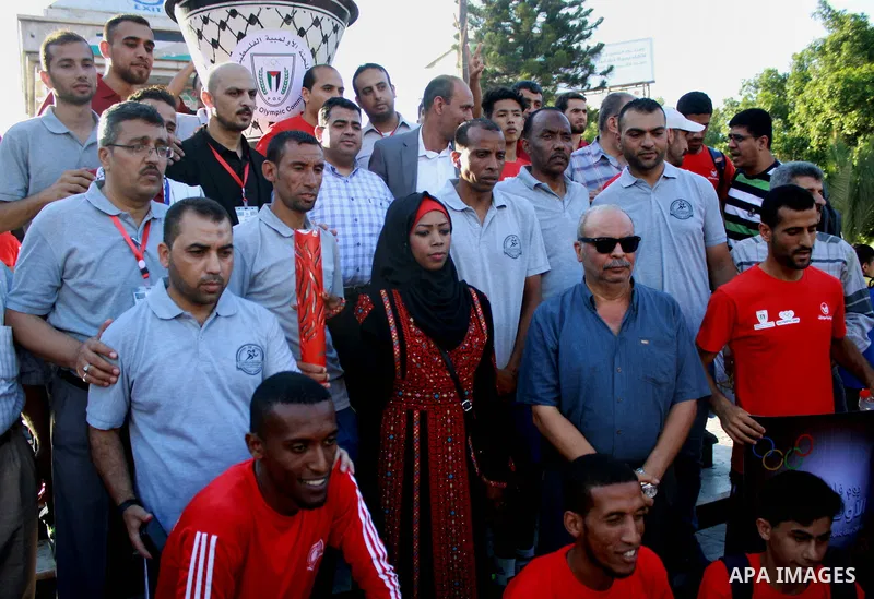 Palestinians light an urn marking the Palestinian Olympic Day, in Gaza city, on June 24, 2018. Photo by Bashar Zakri