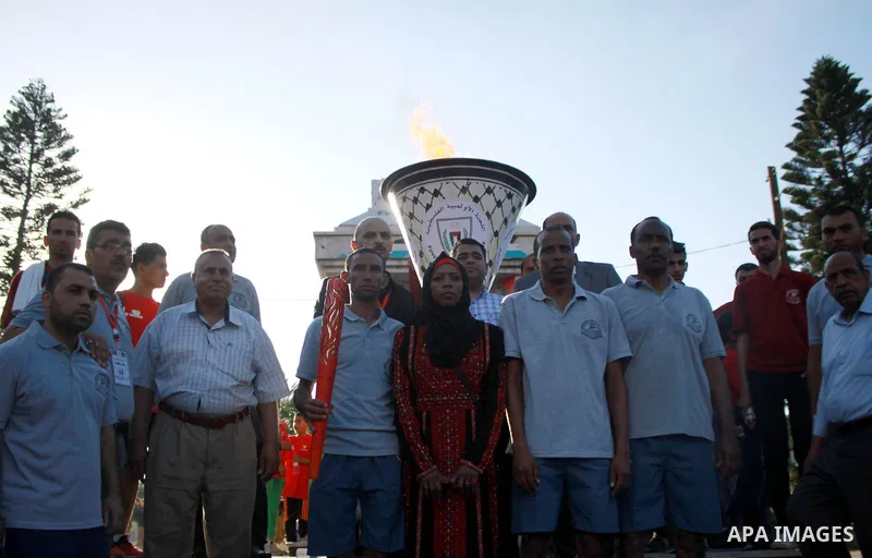 Palestinians light an urn marking the Palestinian Olympic Day, in Gaza city, on June 24, 2018. Photo by Bashar Zakri