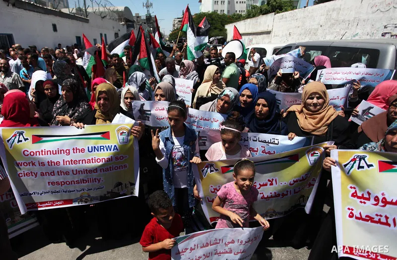 Palestinians hold banners during in a protest against a U.S. decision to cut aid, in front of the headquarters United Nations Relief and Works Agency (UNRWA), in Gaza City on June 25, 2018. Photo by Mahmoud Ajour