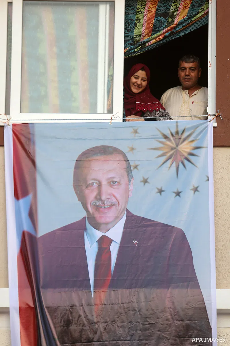 Palestinians hold portraits of Turkish President Recep Tayyip Erdogan and celebrate after Erdogan had won in Turkey's presidential and parliamentary elections, in the center of Gaza Strip on June 25, 2018. Photo by Ashra...