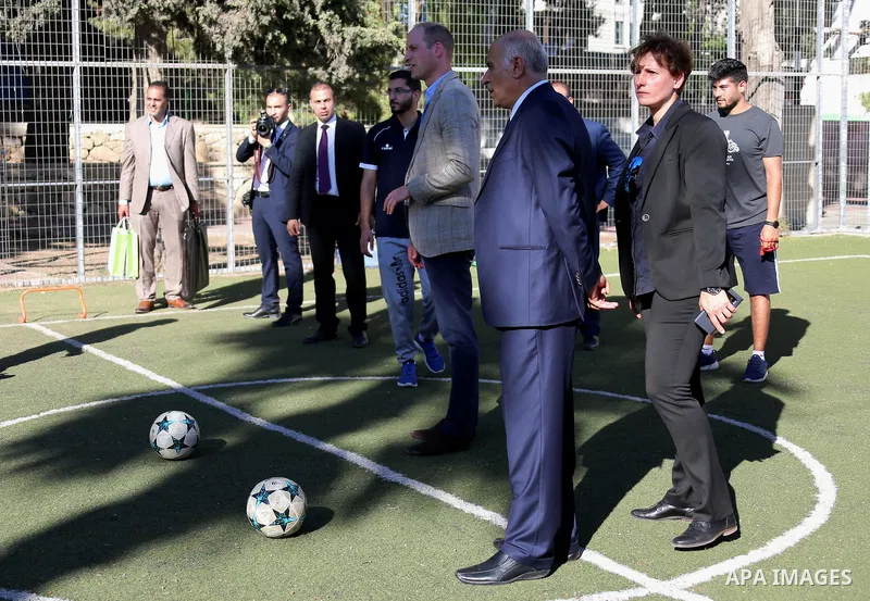 Britain's Prince William shoots a football during his meeting with young Palestinian football players in the West Bank city of Ramallah on June 27, 2018. The Duke of Cambridge is the first member of the royal family to m...