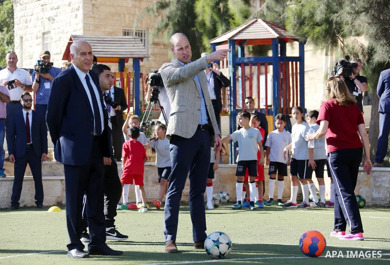 Britain's Prince William shoots a football during his meeting with young Palestinian football players in the West Bank city of Ramallah on June 27, 2018. The Duke of Cambridge is the first member of the royal family to m...