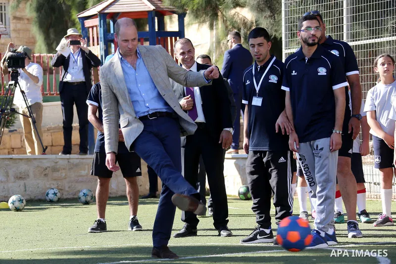 Britain's Prince William shoots a football during his meeting with young Palestinian football players in the West Bank city of Ramallah on June 27, 2018. The Duke of Cambridge is the first member of the royal family to m...