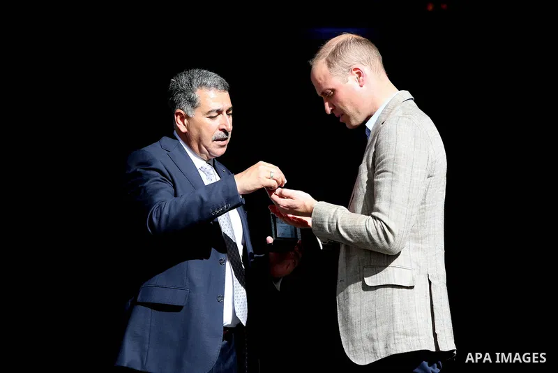 Britain's Prince William receives a gift from Musa Hadid, the mayor of Ramallah, at a reception during his visit to the West Bank city's municipality on June 27, 2018. The Duke of Cambridge is the first member of the roy...