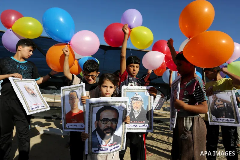 Palestinian children hold balloons before it be fly during a protest near tents at Gaza-Israel border, in Jabalia in the northern of Gaza Strip on June 27, 2018. Photo by Ashraf Amra