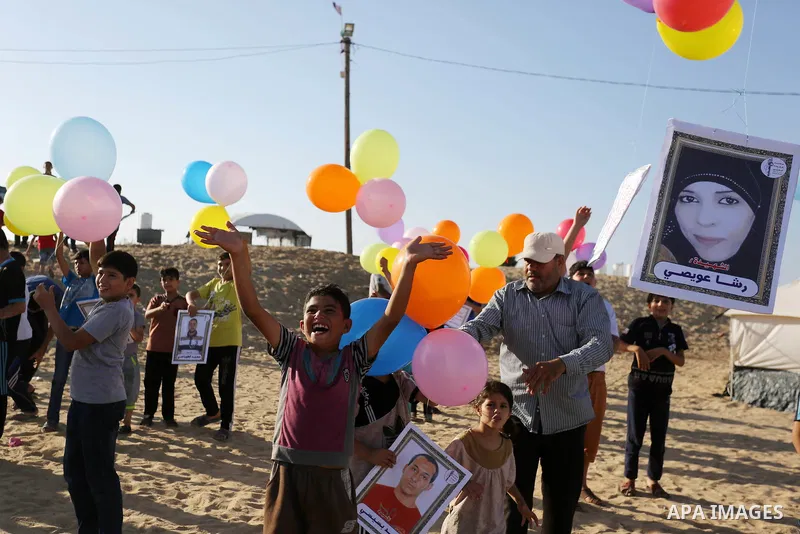 Palestinian children hold balloons before it be fly during a protest near tents at Gaza-Israel border, in Jabalia in the northern of Gaza Strip on June 27, 2018. Photo by Ashraf Amra