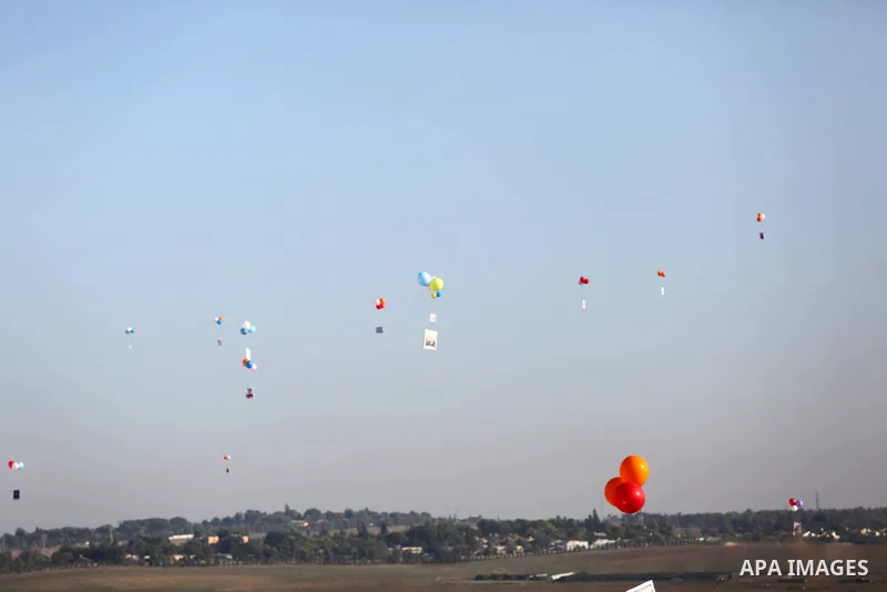 Balloons being flown by Palestinian children during a protest near tents at Gaza-Israel border, in Jabalia in the northern of Gaza Strip on June 27, 2018. Photo by Ashraf Amra